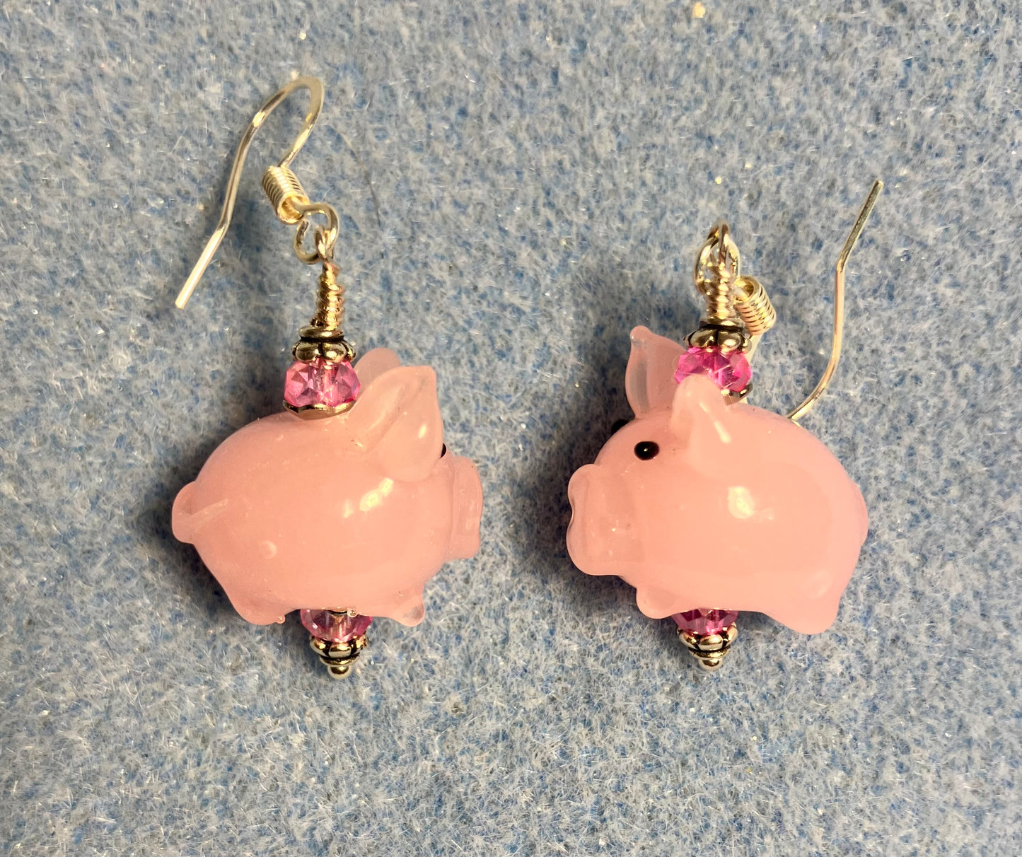 Small light pink lamp work pig bead earrings adorned with hot pink Chinese crystal beads.