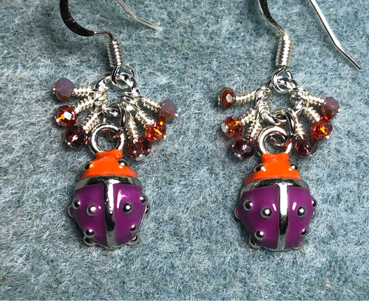 Tiny purple, orange, and silver enamel ladybug charm earrings adorned with tiny dangling purple and orange Chinese crystal beads.