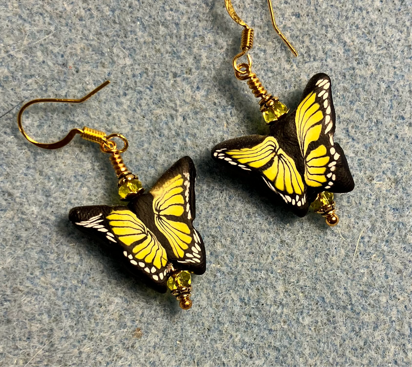 Yellow and black polymer clay butterfly bead earrings adorned with yellow Chinese crystal beads.