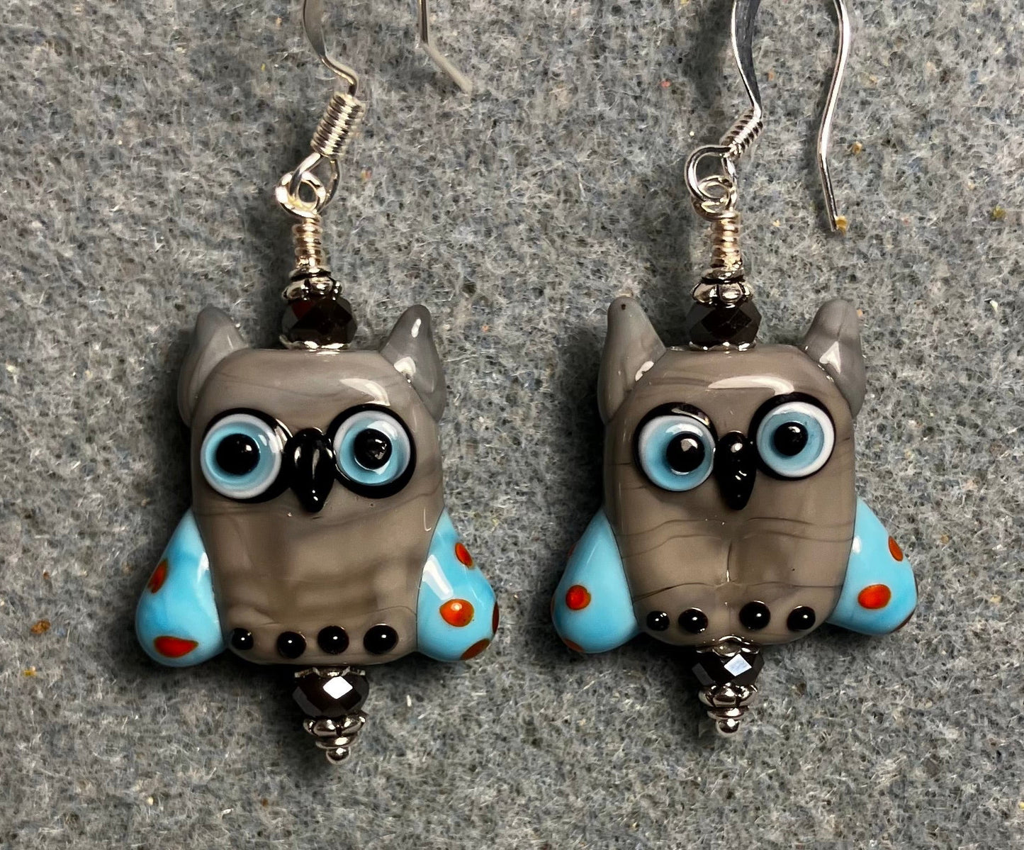 Gray and blue lamp work owl bead earrings adorned with gray Chinese crystal beads.
