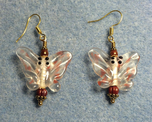 Clear and orange lamp work butterfly bead earrings adorned with dark orange Czech glass beads.