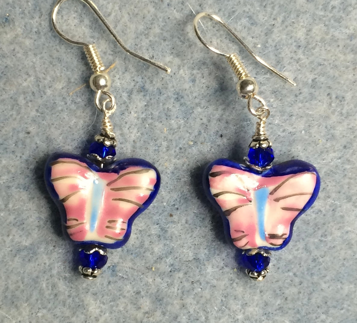 Dark blue and pink ceramic butterfly bead earrings adorned with dark blue Chinese crystal beads.