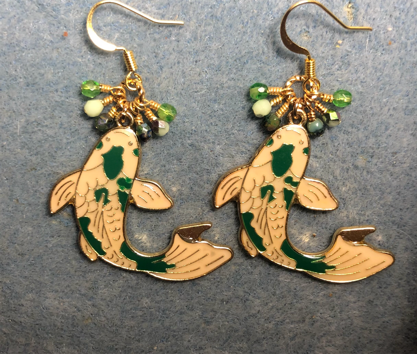 Large green and white enamel koi charm earrings adorned with tiny dangling green and white Czech glass beads.