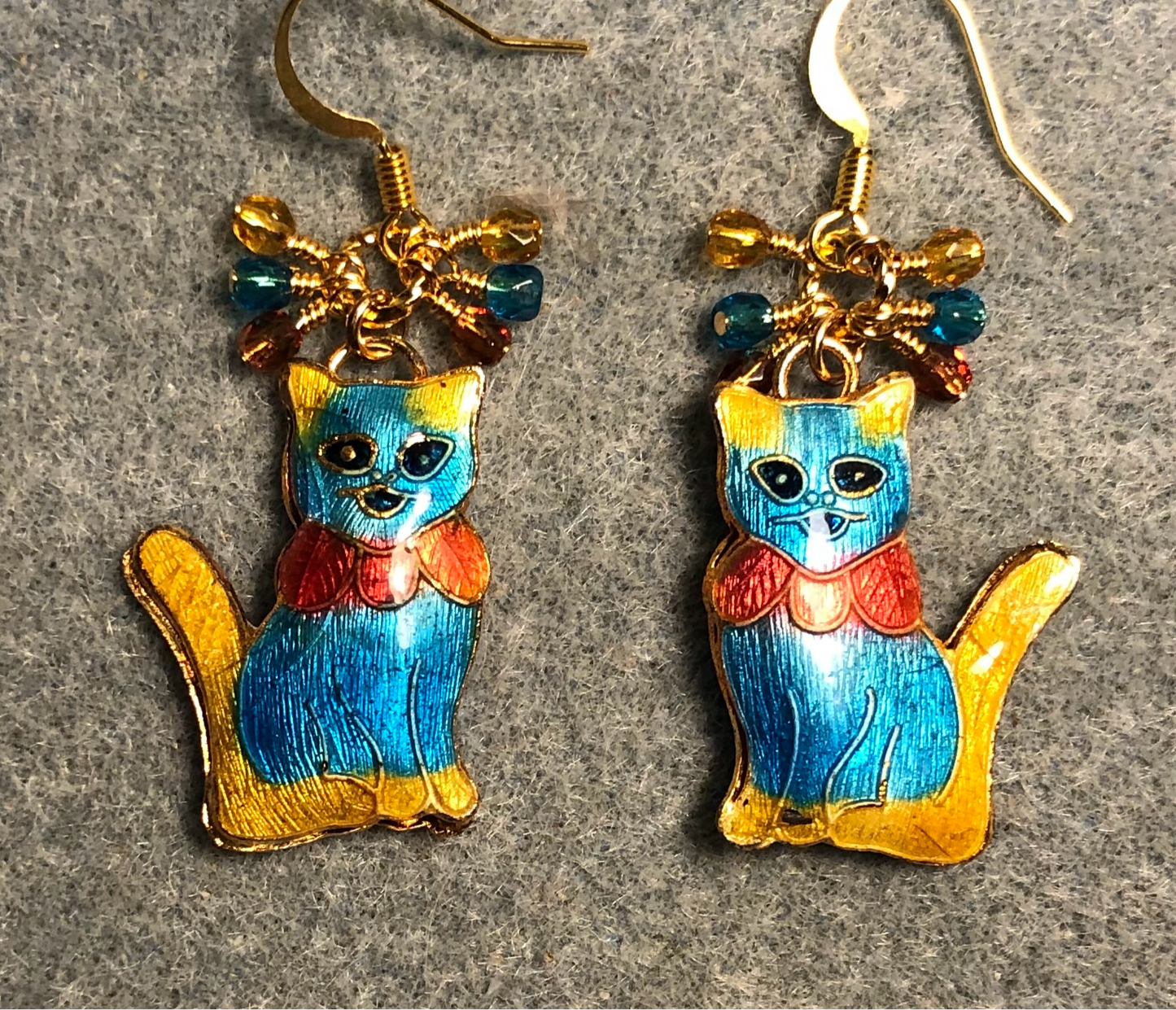Turquoise, orange, and amber cloisonné cat charm earrings adorned with small dangling turquoise, orange, and amber Czech glass beads.