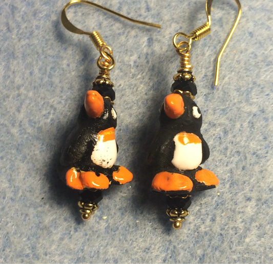 Small black, orange, and white ceramic penguin bead earrings adorned with black Chinese crystal beads.