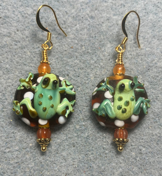 Orange and green lamp work frog bead earrings adorned with orange Czech glass beads.