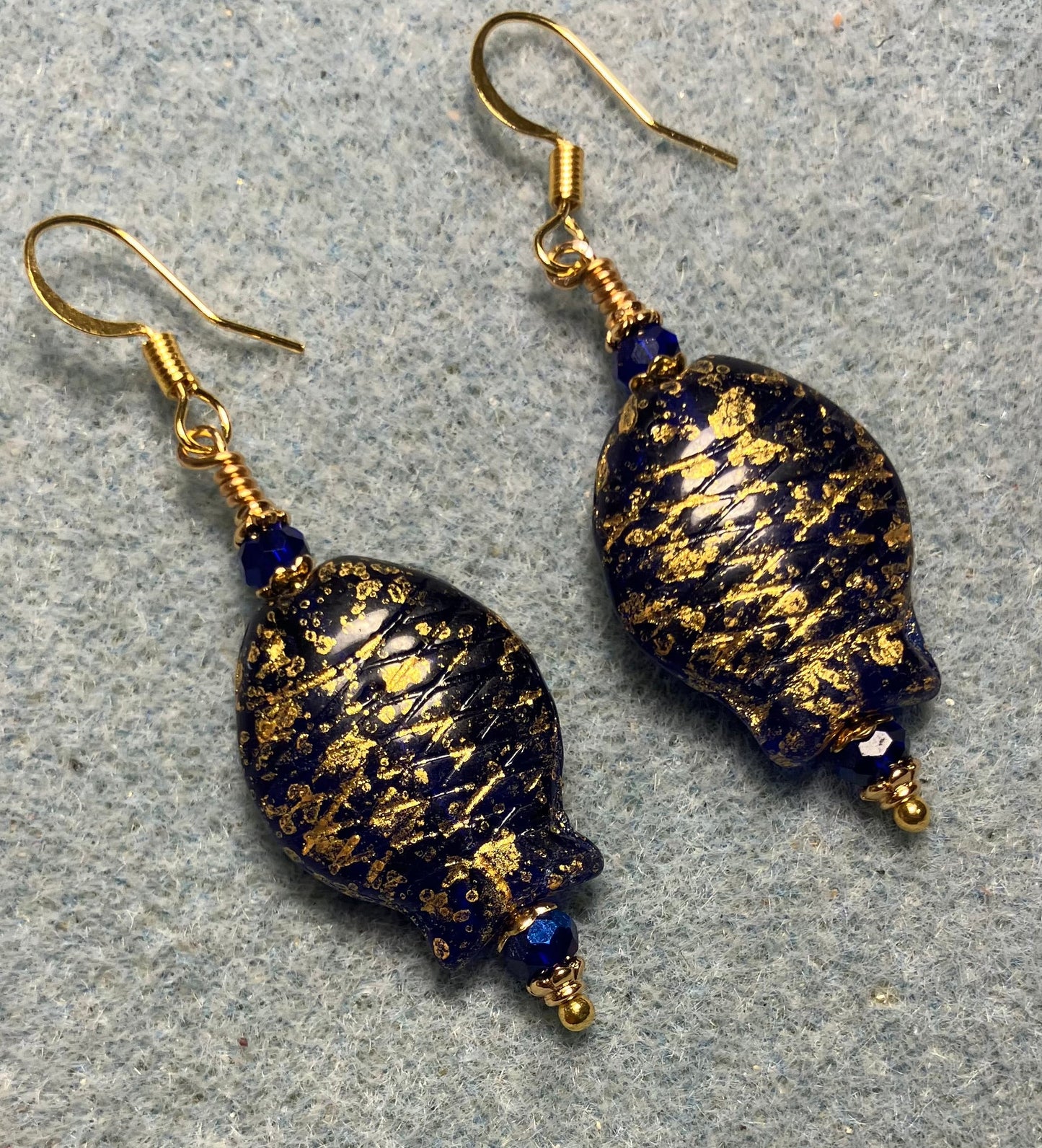 Dark blue and gold Czech glass fish bead earrings adorned with dark blue Chinese crystal beads.
