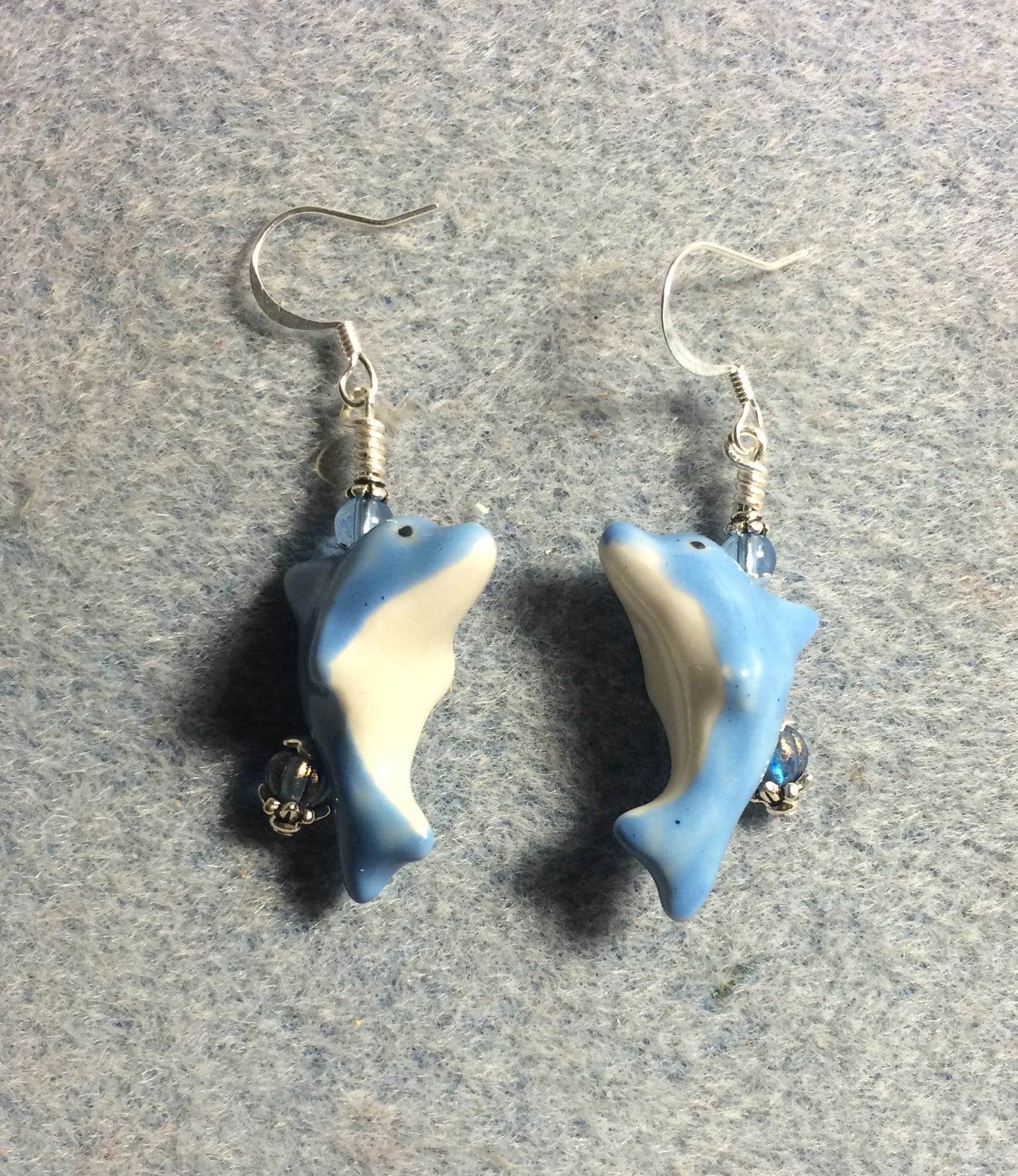 Light blue and white ceramic dolphin bead earrings adorned with light blue Czech glass beads.