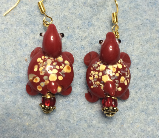 Opaque dark red lamp work spotted turtle bead earrings adorned with dark red Czech glass beads.