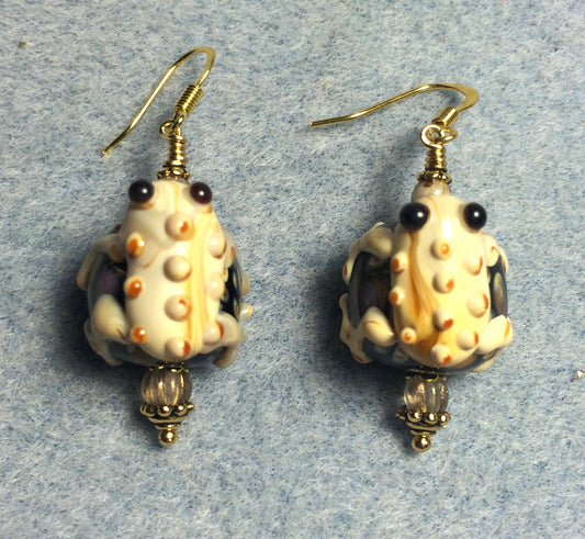 Large tan and black lamp work toad bead earrings adorned with tan Czech glass beads.