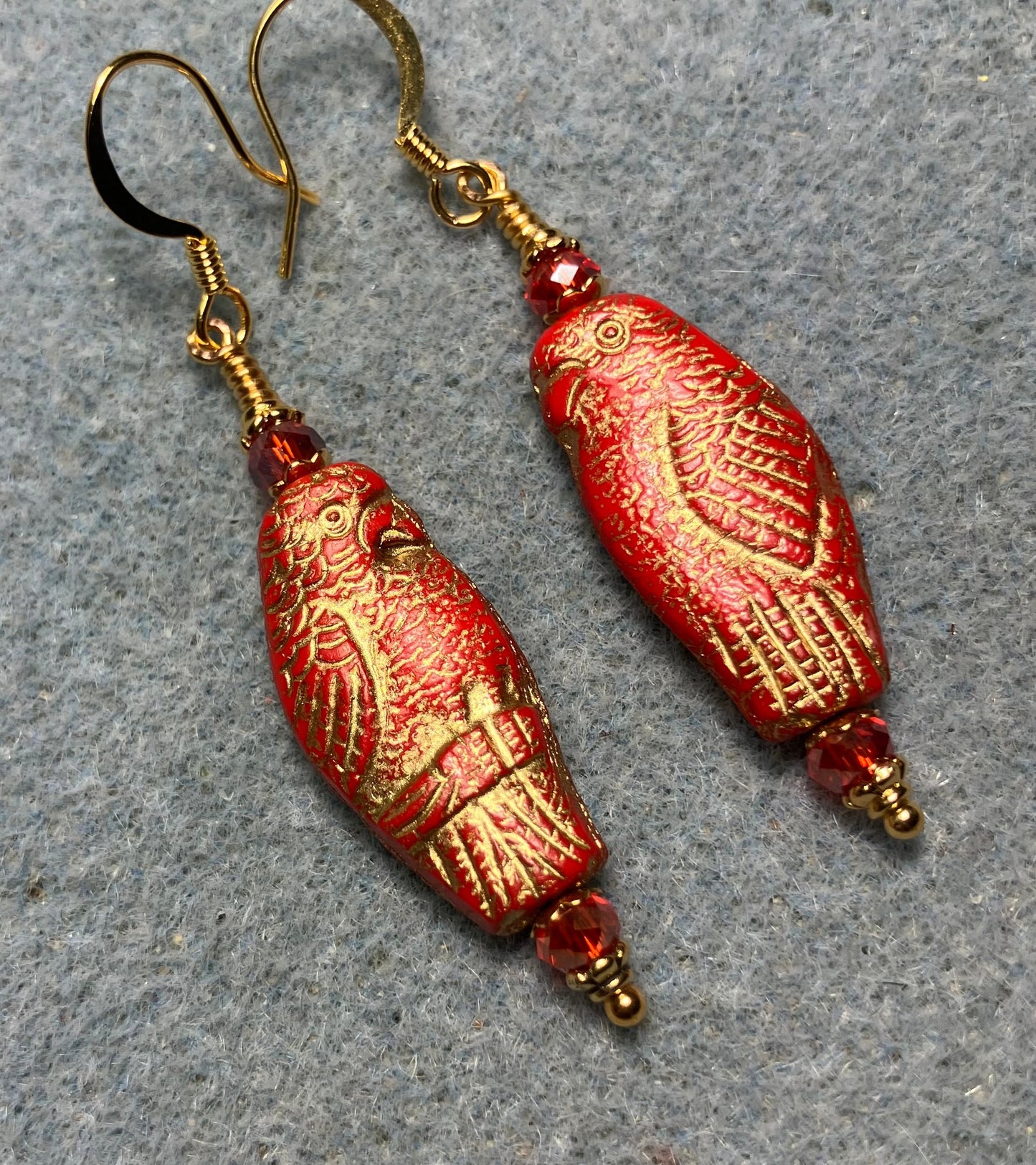Large red (with gold wash) Czech glass parrot bead earrings adorned with red Chinese crystal beads.
