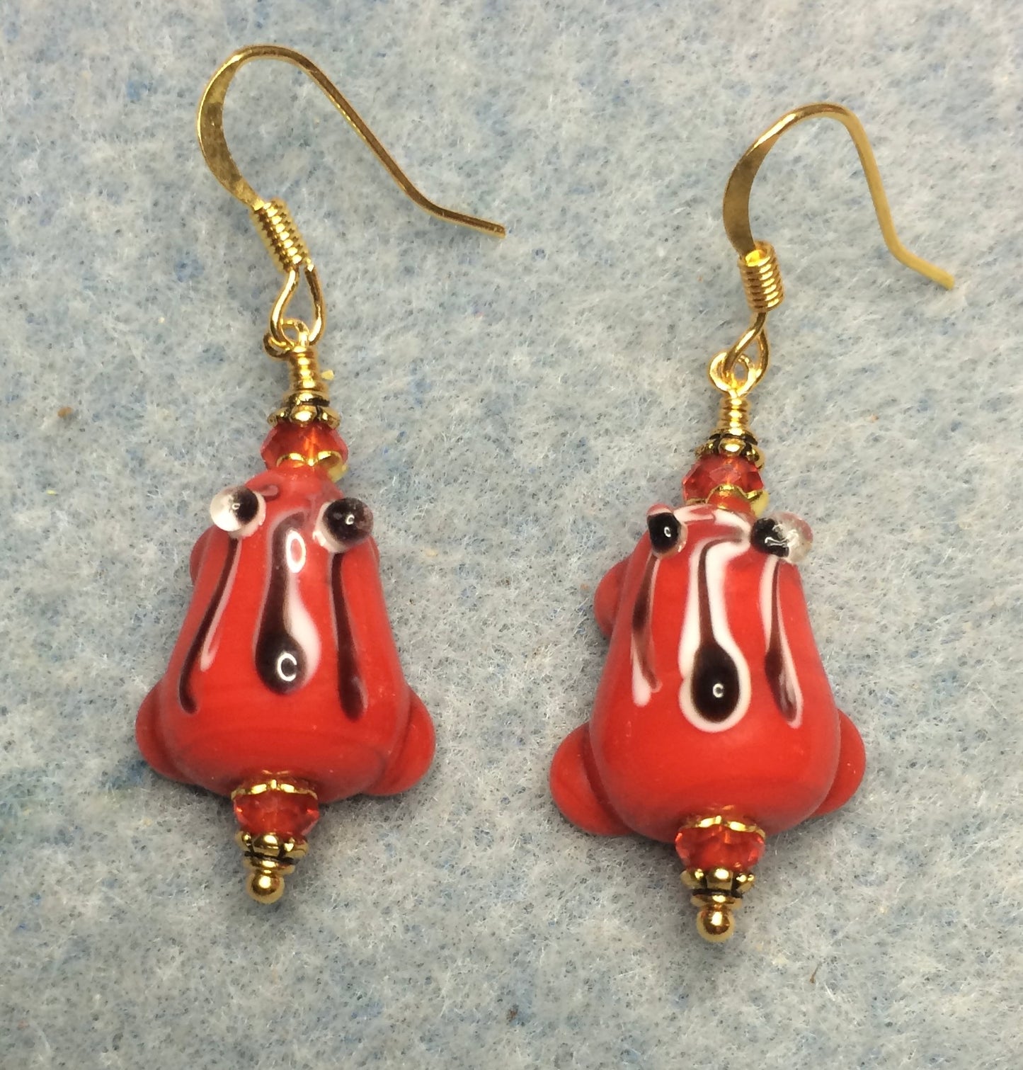 Red with black stripes lamp work frog bead earrings adorned with red Chinese crystal beads.