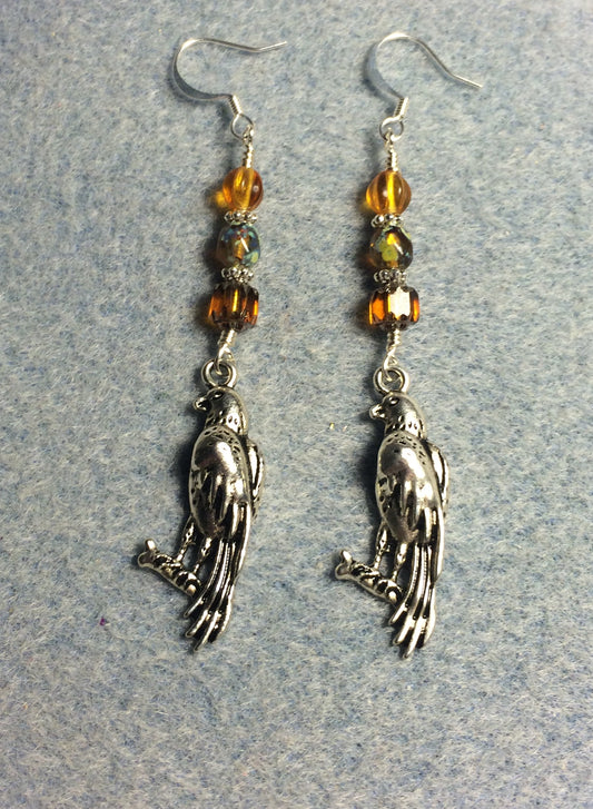 Long silver falcon charm earrings adorned with amber Czech glass beads