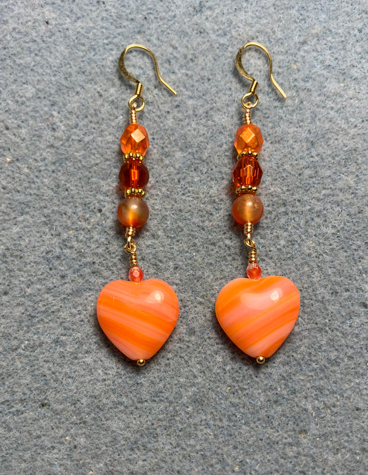 Opaque striped orange Czech glass heart bead earrings adorned with orange Czech glass beads.