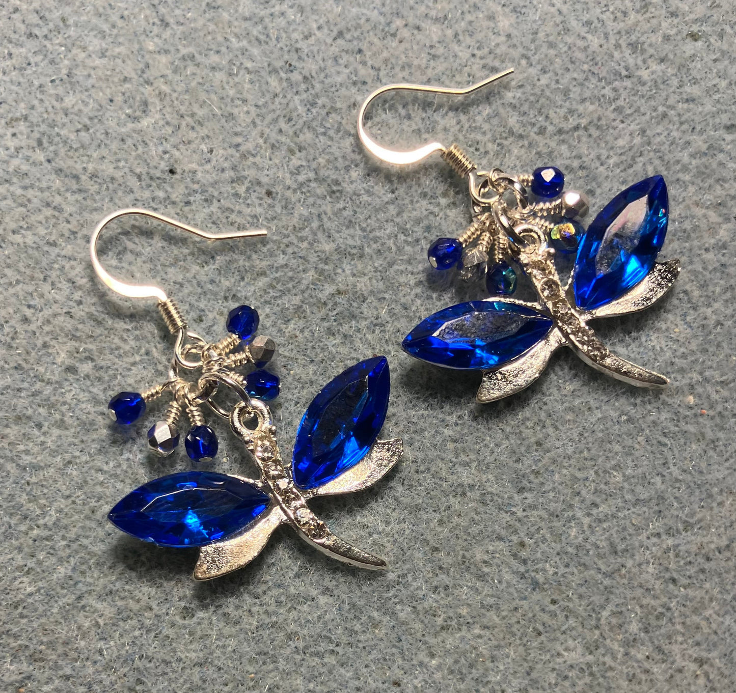 Dark blue and silver rhinestone dragonfly charm earrings adorned with small dangling dark blue and silver Czech glass beads.