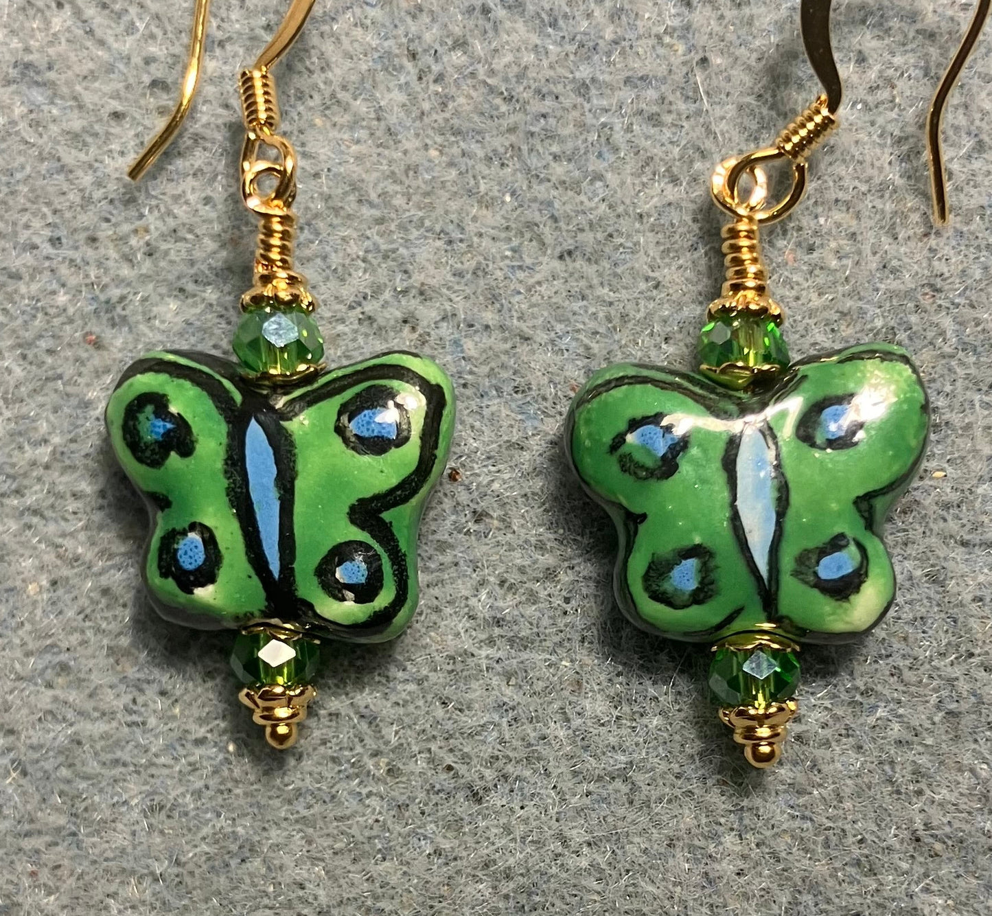 Green, black, and light blue ceramic butterfly bead earrings adorned with green Chinese crystal beads.
