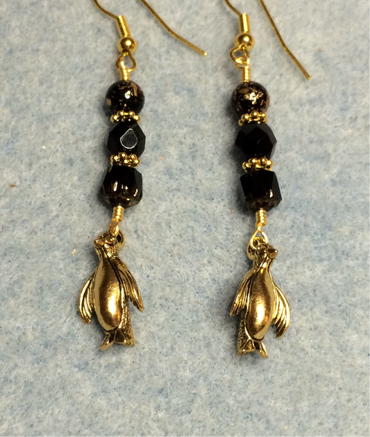 Gold penguin charm earrings adorned with black Czech glass beads