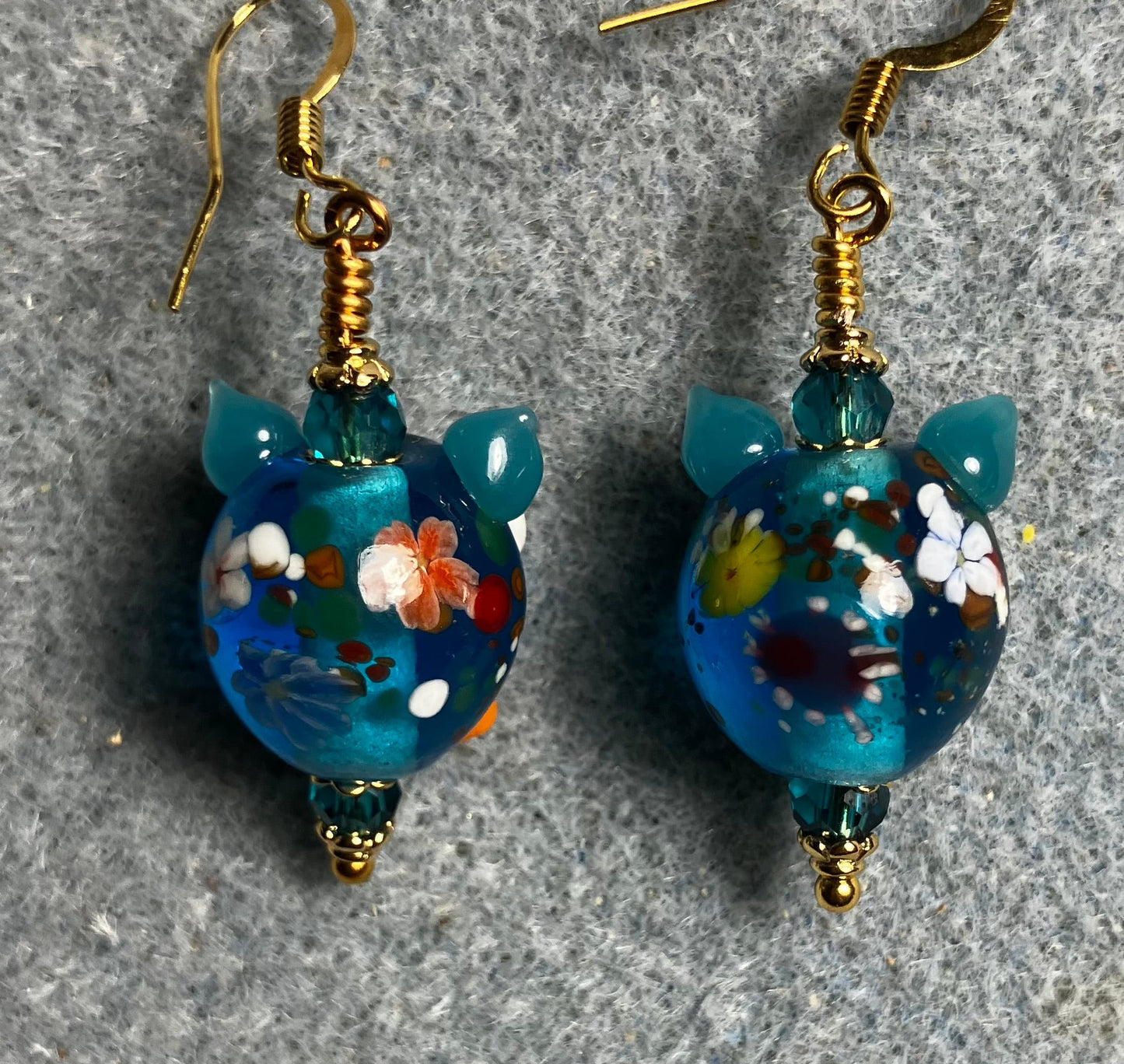 Turquoise, orange, and red lamp work owl bead earrings adorned with turquoise Chinese crystal beads.