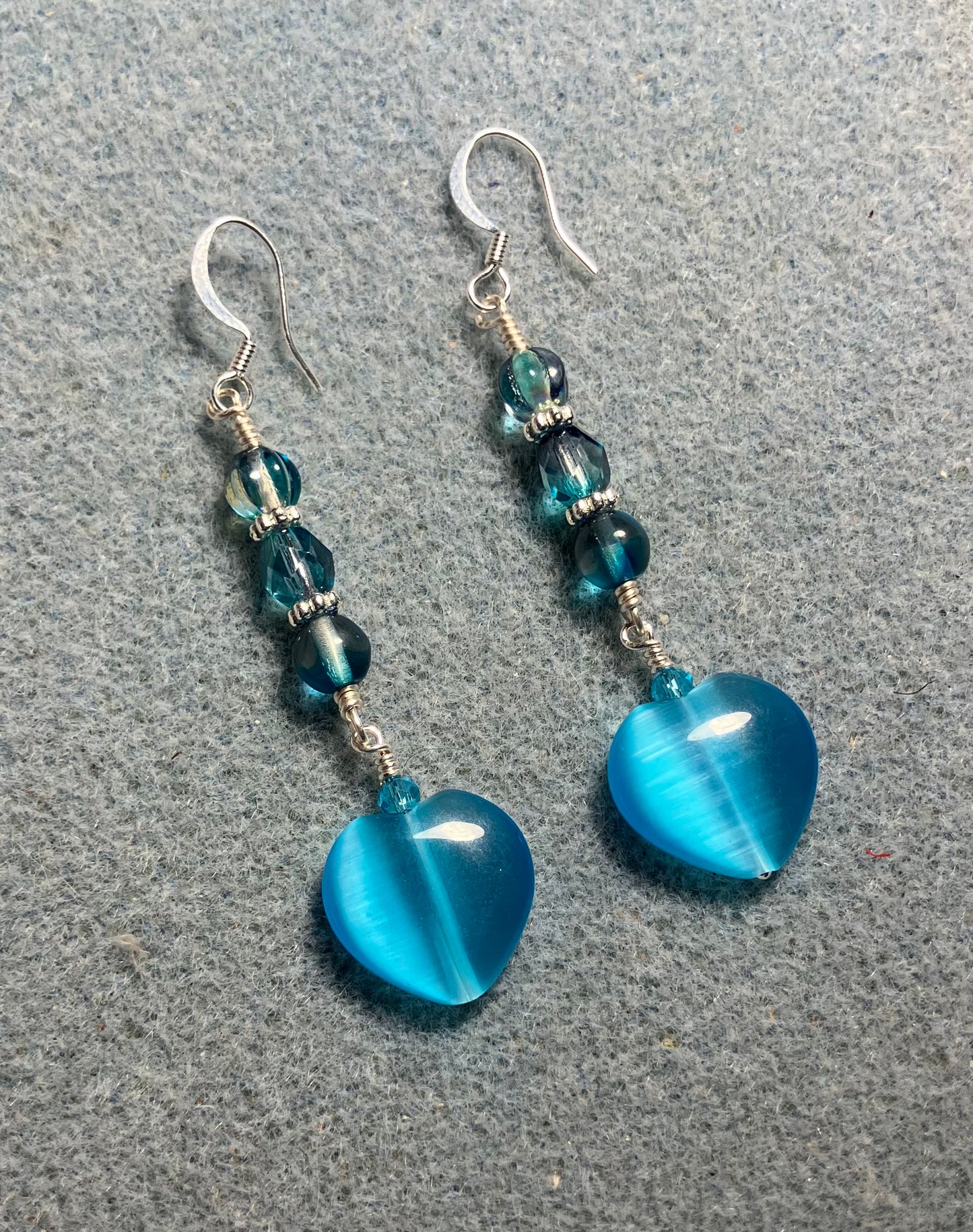 Turquoise fiber optic (cat’s eye) Czech glass heart bead earrings adorned with turquoise Czech glass beads.