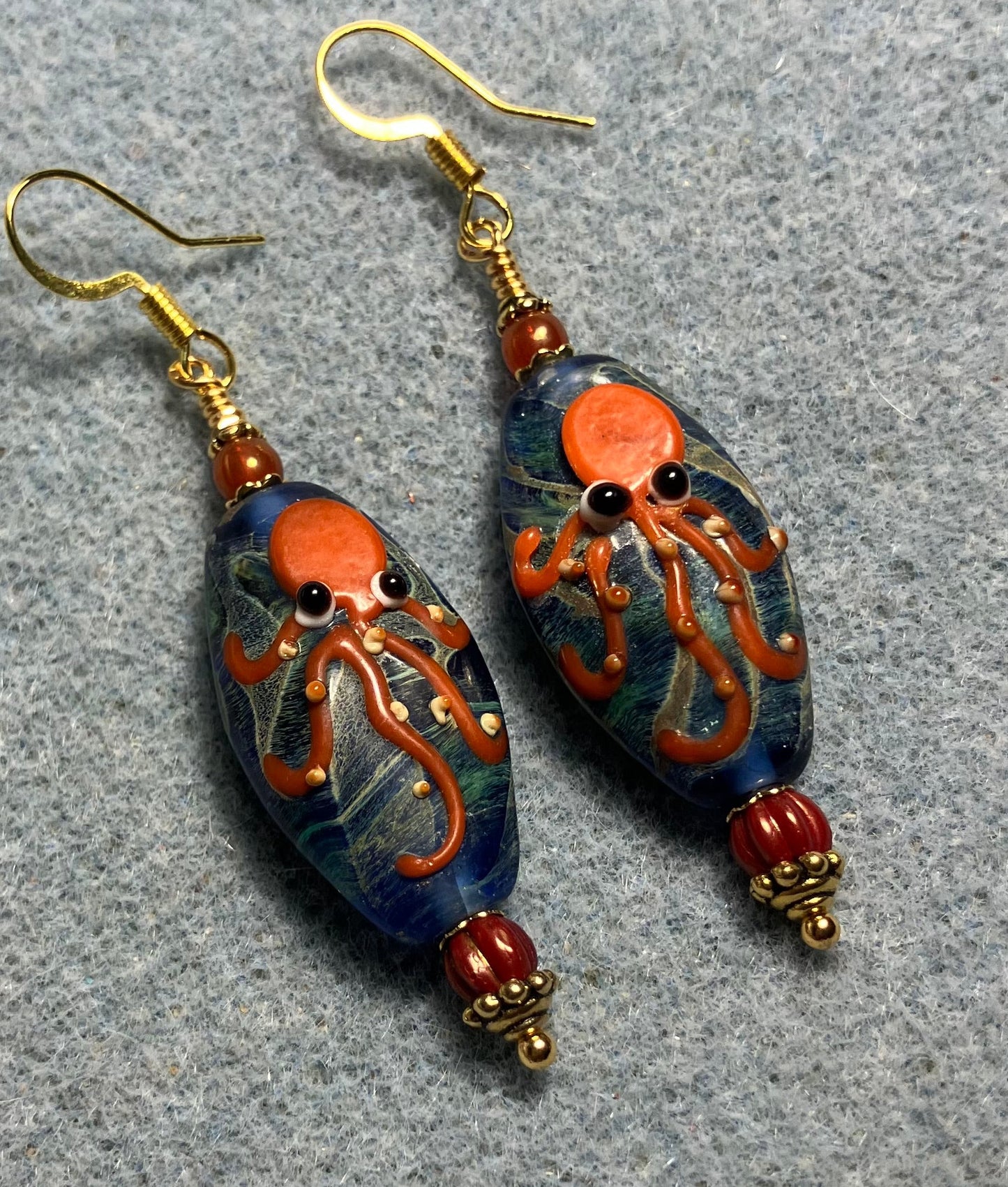 Blue and orange lamp work octopus bead earrings adorned with orange Czech glass beads.