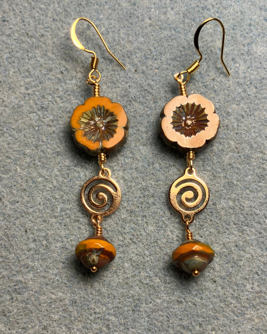 Mustard yellow Czech glass pansy bead earrings adorned with gold swirly connectors and mustard yellow Czech glass Saturn beads.