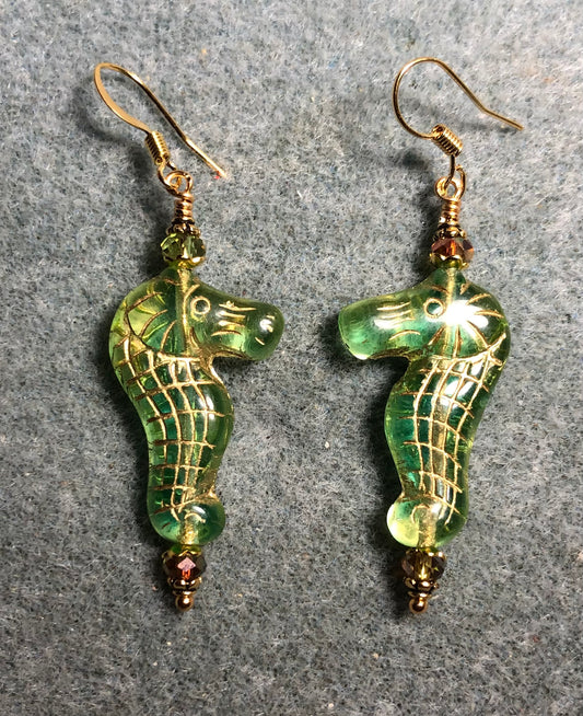 Green (with gold inlay) Czech glass seahorse bead earrings adorned with sparkly green Chinese crystal beads.