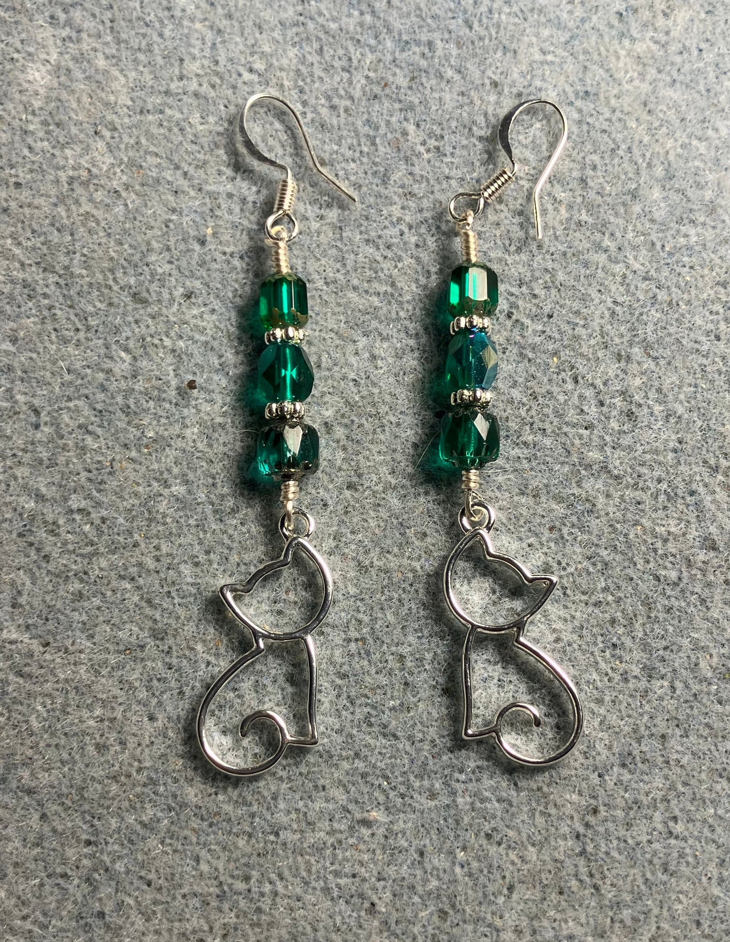 Silver silhouette cat charm earrings adorned with teal Czech glass beads.
