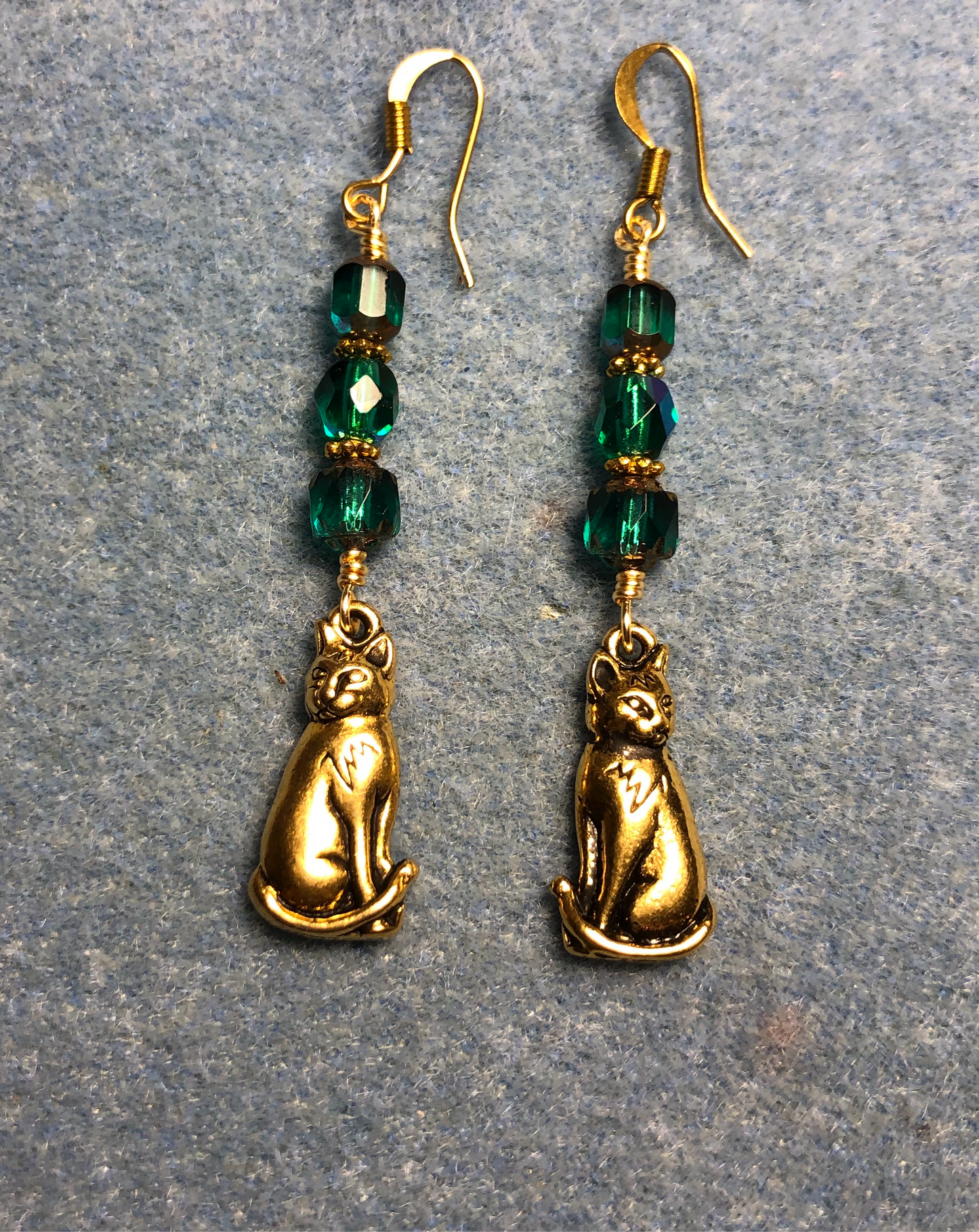 Gold cat charm earrings adorned with teal Czech glass beads