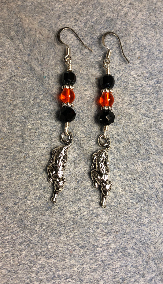 Silver stretching jaguar charm earrings adorned with black and orange Czech glass beads