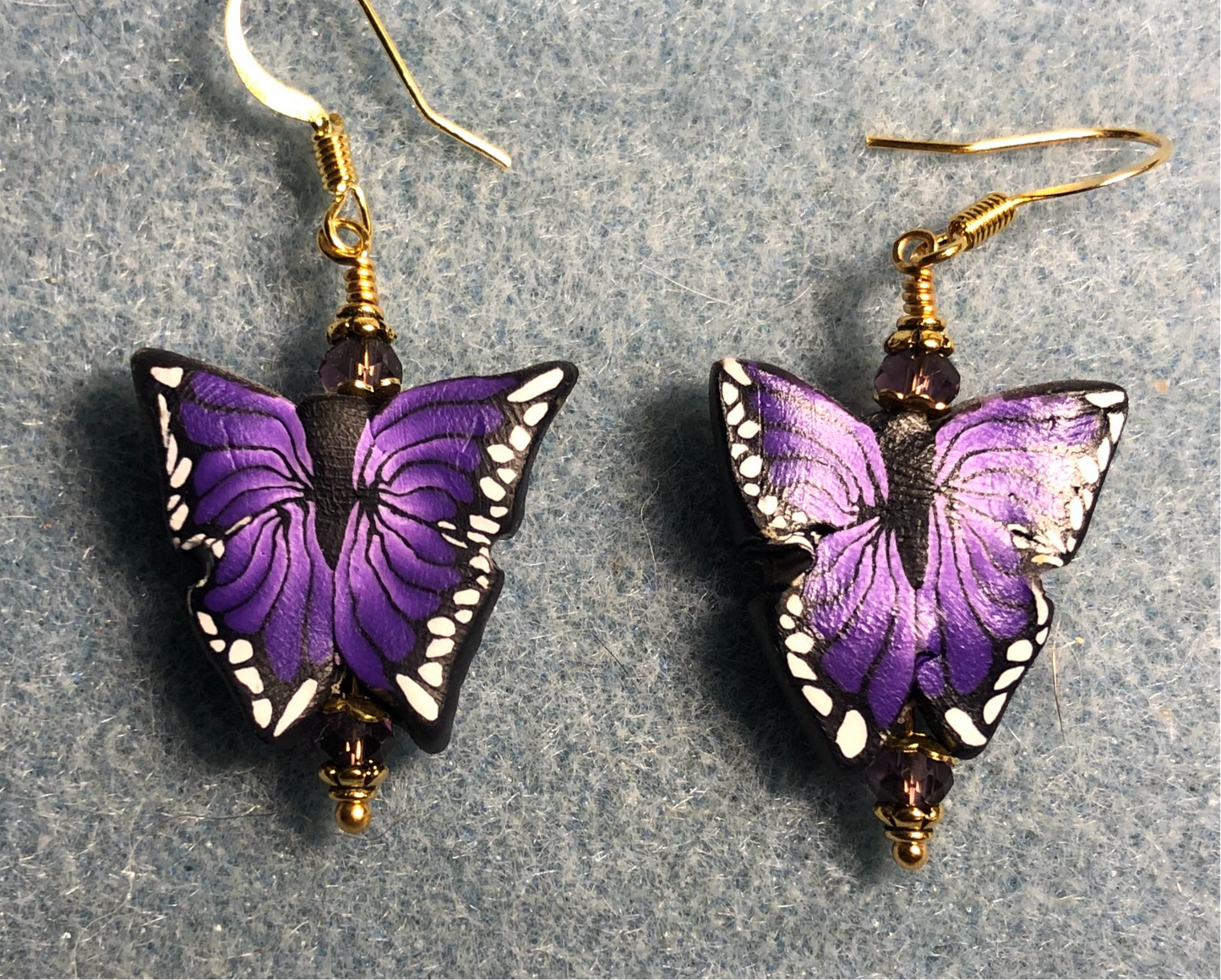 Purple and black polymer clay butterfly bead earrings adorned with purple Chinese crystal beads.