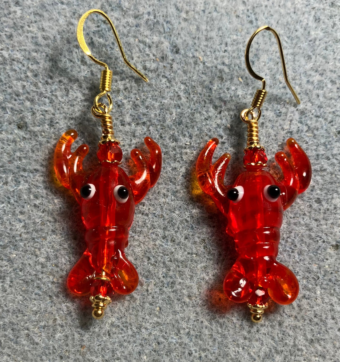 Red lamp work lobster bead earrings adorned with red Chinese crystal beads.