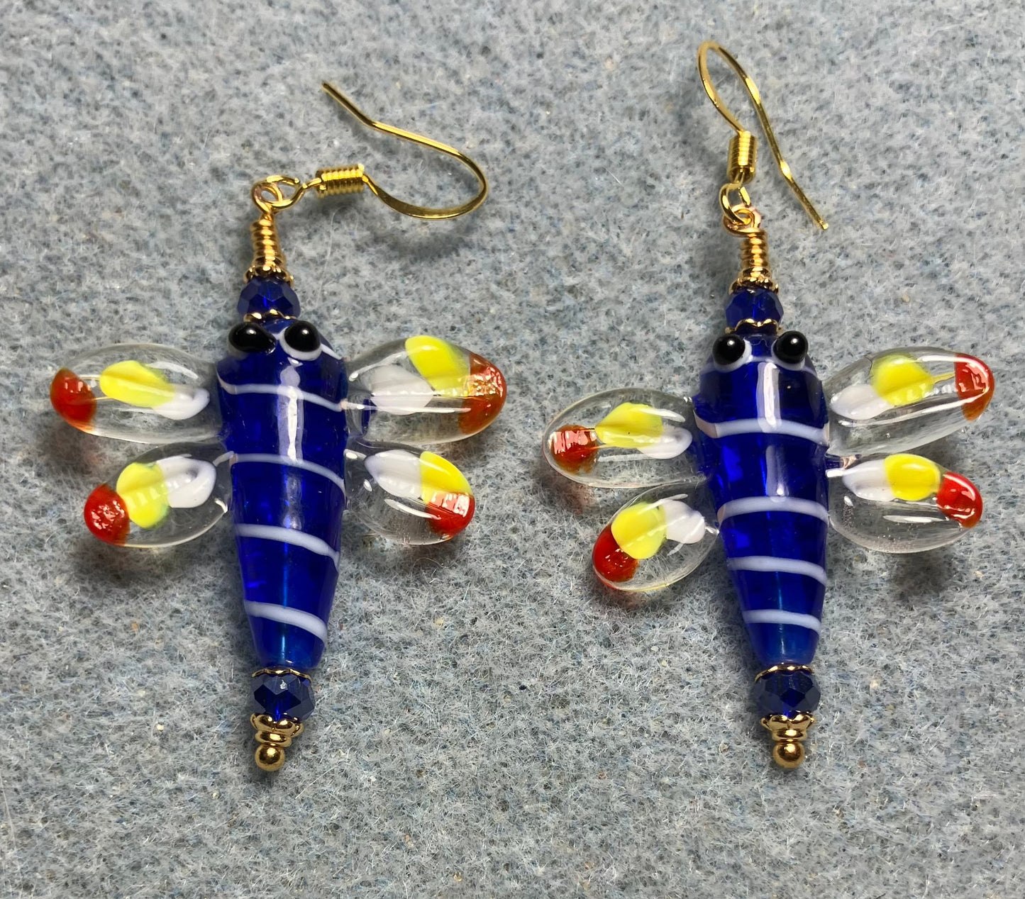 Dark blue, red, and yellow lamp work dragonfly bead earrings adorned with dark blue Chinese crystal beads.