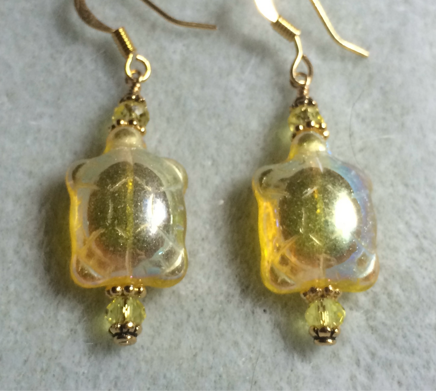 Iridescent yellow Czech glass turtle bead earrings adorned with yellow Chinese crystal beads.