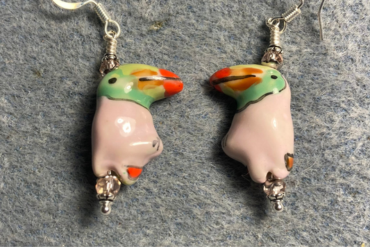 Light pink and green ceramic toucan bead earrings adorned with light pink Chinese crystal beads.