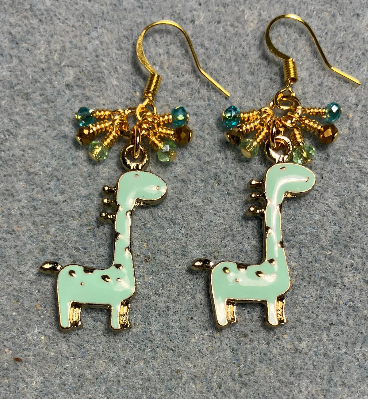 Light aqua enamel spotted giraffe charm earrings adorned with tiny dangling aqua, gold, and light green Chinese crystal beads.