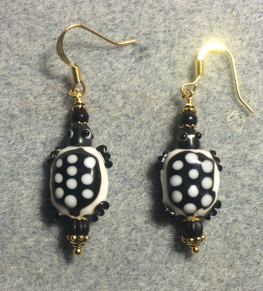 Black and white lamp work spotted turtle bead earrings adorned with black Czech glass beads.