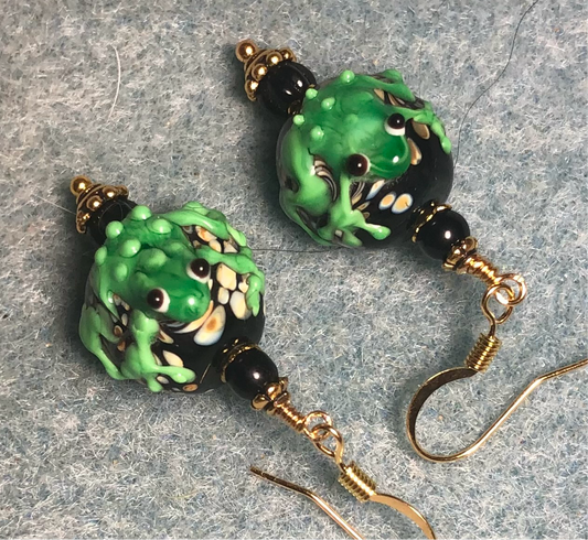 Black and bright green lamp work frog bead earrings adorned with black Czech glass beads.