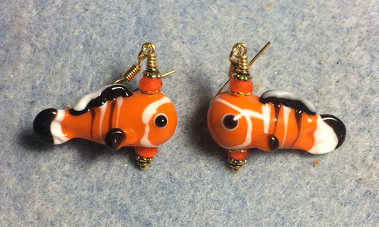 Orange, black, and white lamp work fish bead earrings adorned with orange Chinese crystal beads.