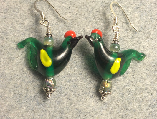 Translucent dark green and yellow lamp work songbird bead earrings adorned with green Czech glass beads.