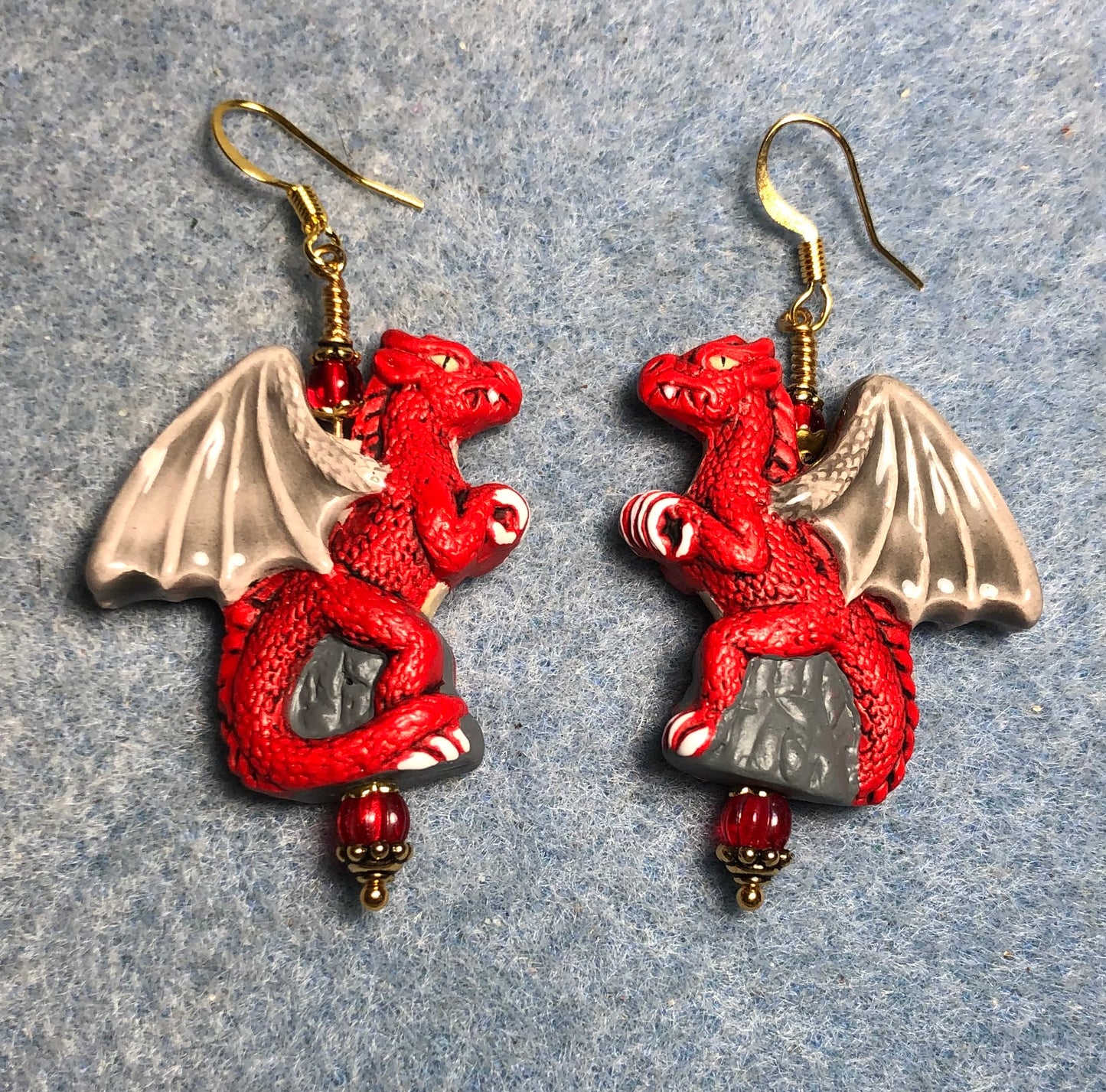 Large red dragon bead earrings adorned with red Czech glass beads.