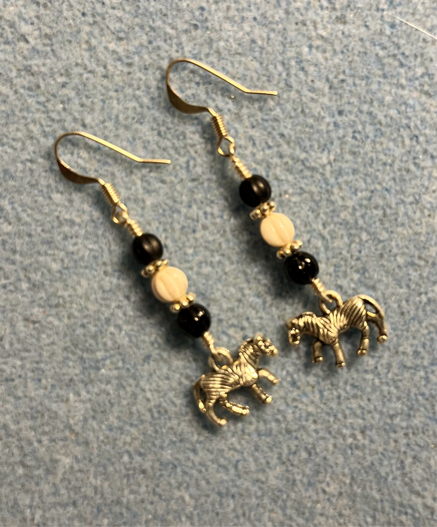 Small silver zebra charm earrings adorned with black and white Czech glass melon beads.