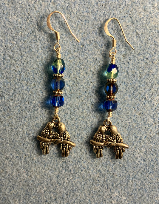 Silver lovebird charm earrings adorned with blue and blue green Czech glass beads.