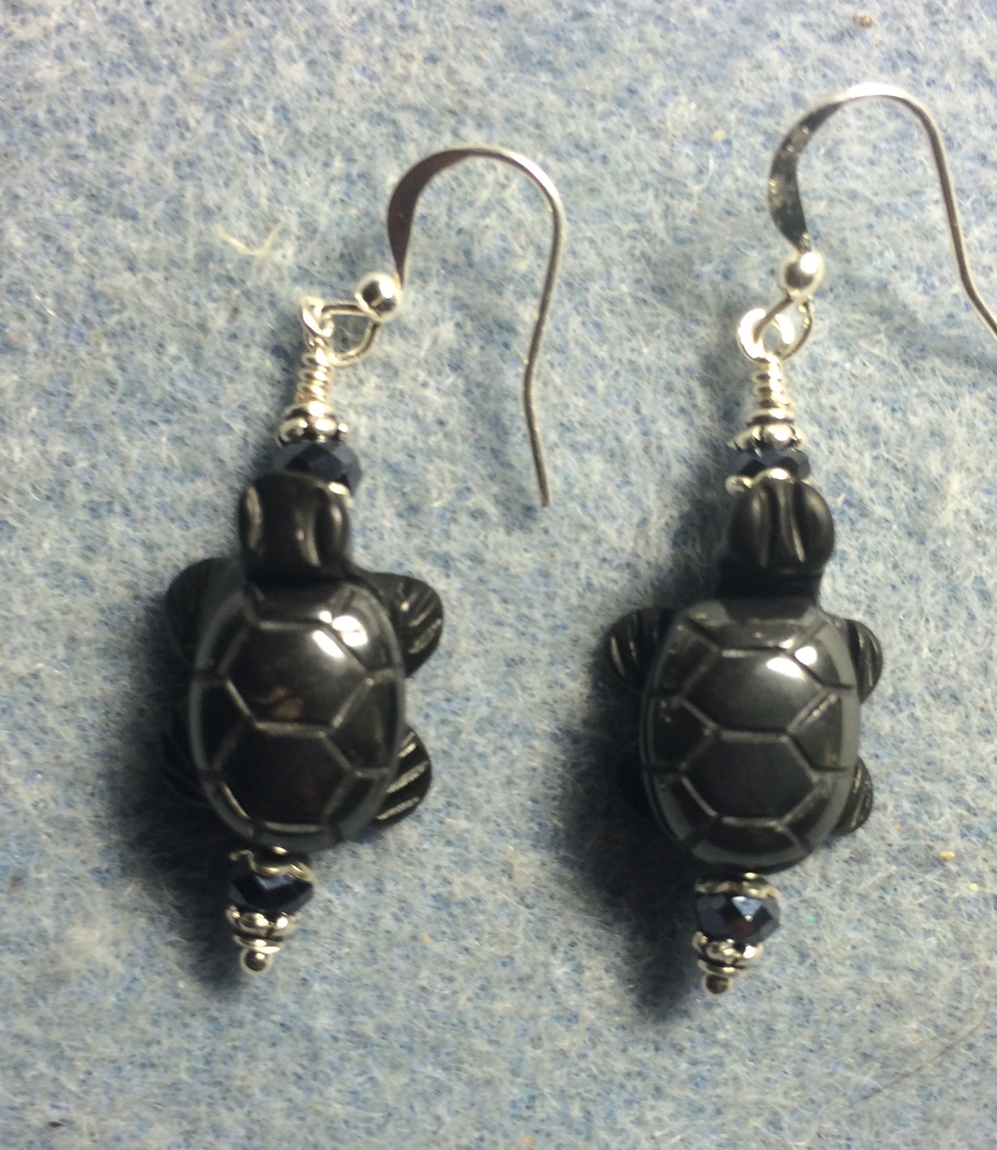 Small hematite gemstone turtle bead earrings adorned with black Chinese crystal beads.