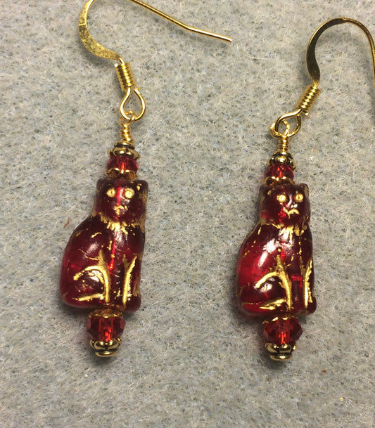 Small translucent red and gold Czech glass cat bead earrings adorned with red Chinese crystal beads.