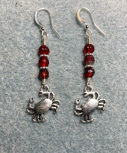 Silver crab charm earrings adorned with small dark red Czech glass beads.