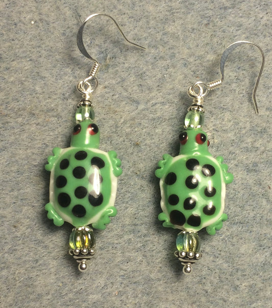 Green and white lamp work spotted turtle bead earrings adorned with green Czech glass beads.