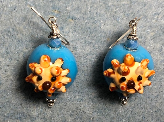 Opaque spherical turquoise and tan lamp work lion bead earrings adorned with opaque turquoise Chinese crystal beads.
