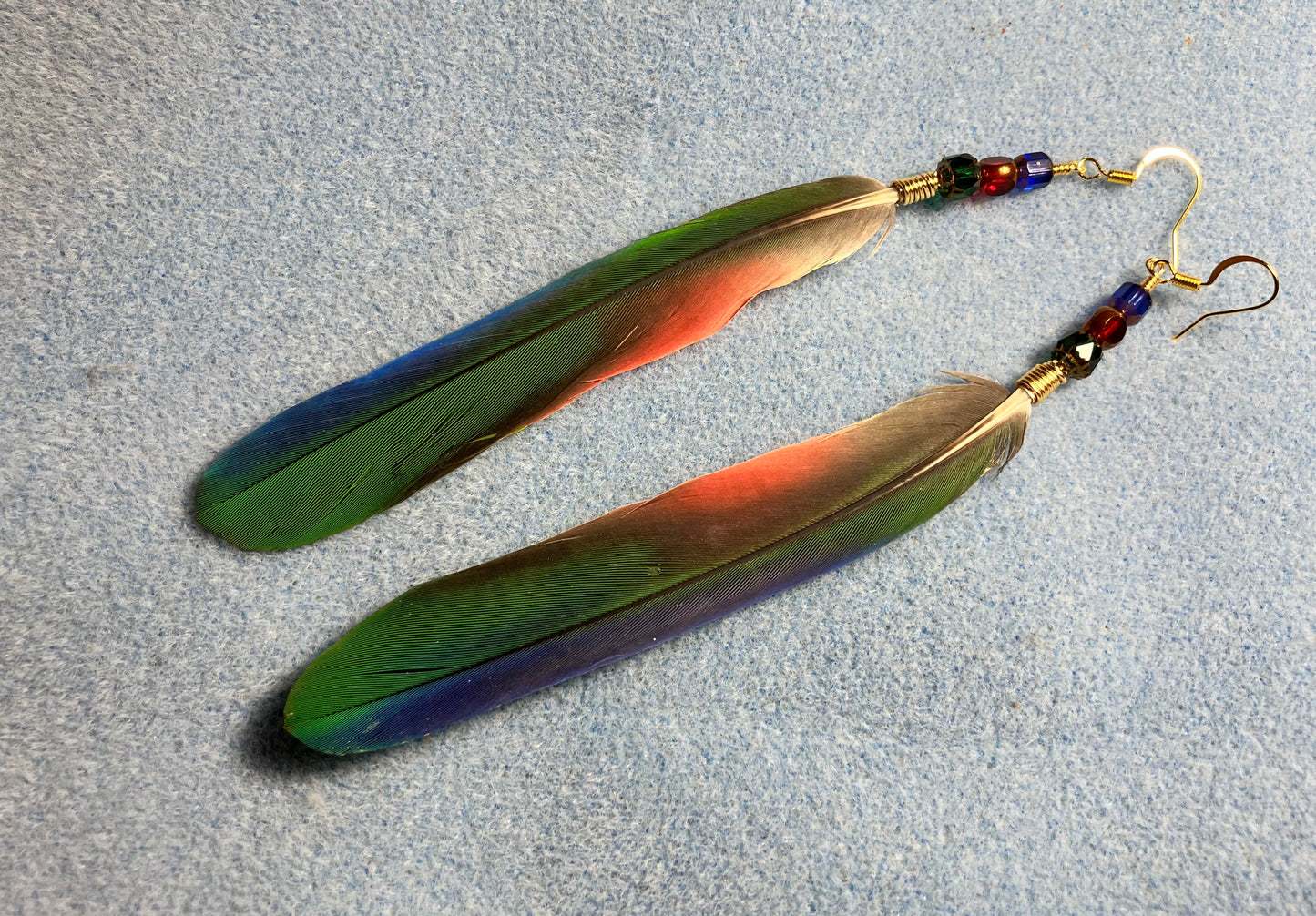 Green, red, and blue Pionus parrot feather earrings adorned with green, red, and blue Czech glass beads