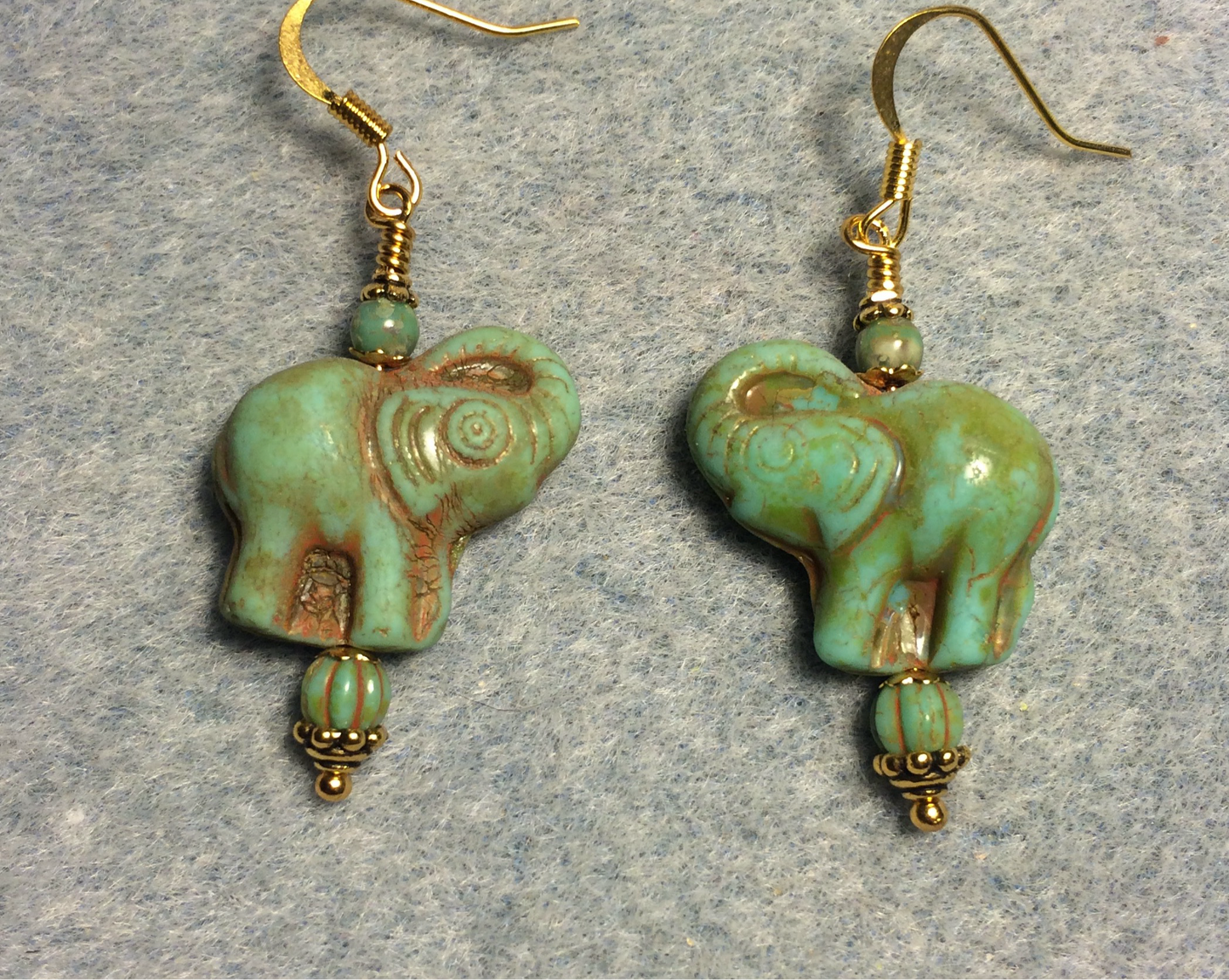 Green (with tan inlay) Czech glass elephant bead earrings adorned with green Czech glass beads.