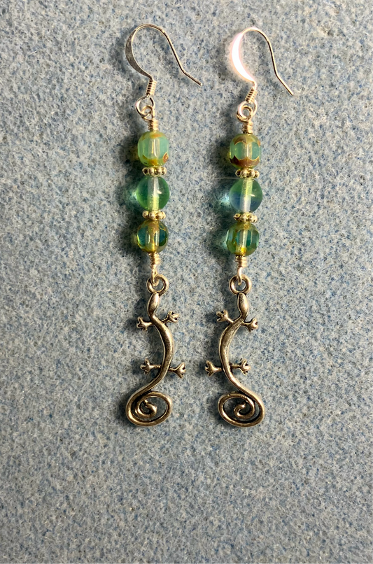 Long silver swirly tailed lizard charm earrings adorned with light green Czech glass beads